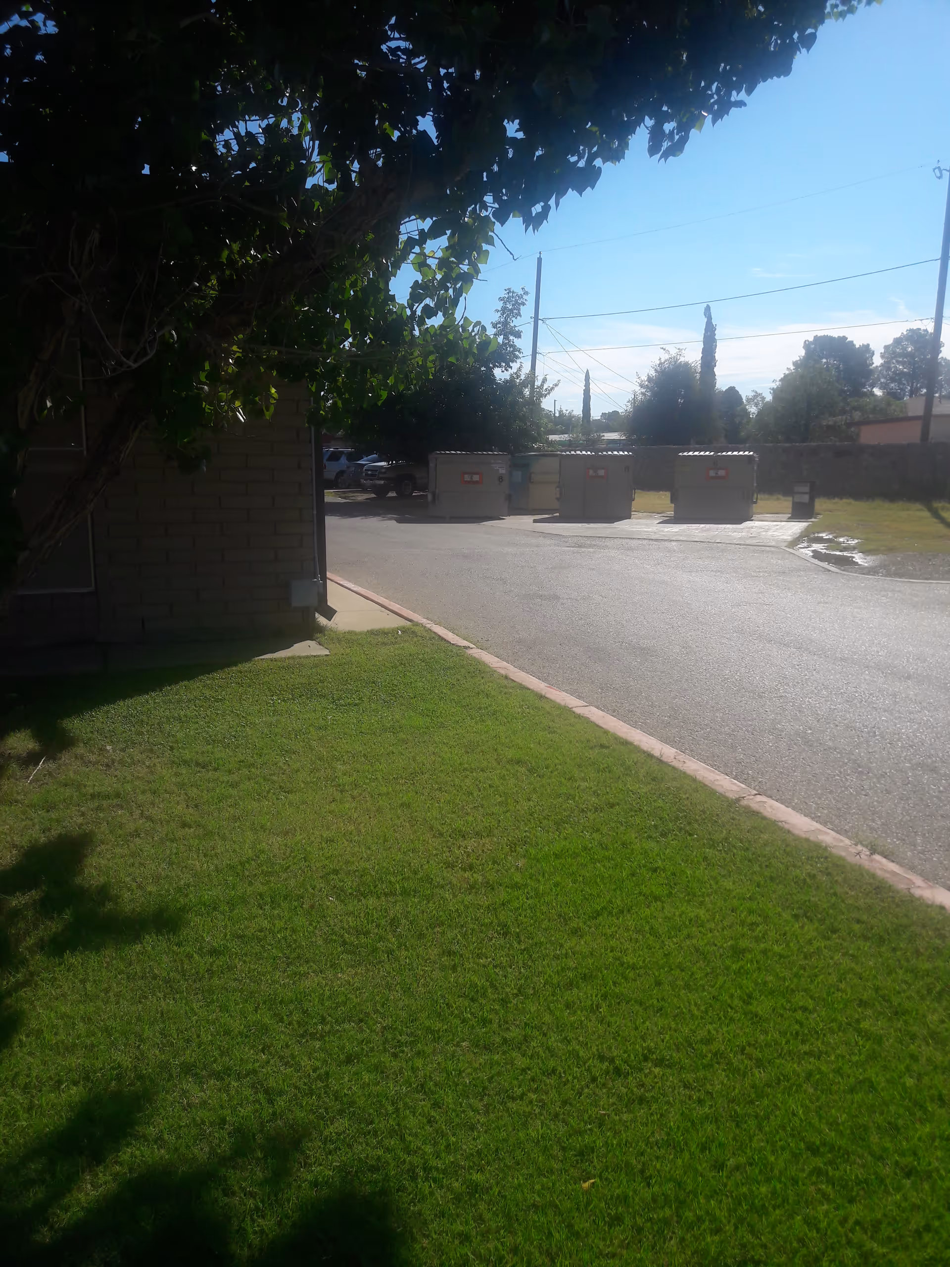 Exterior view of Oasis Nursing and Rehabilitation Center with dumpsters along a driveway.