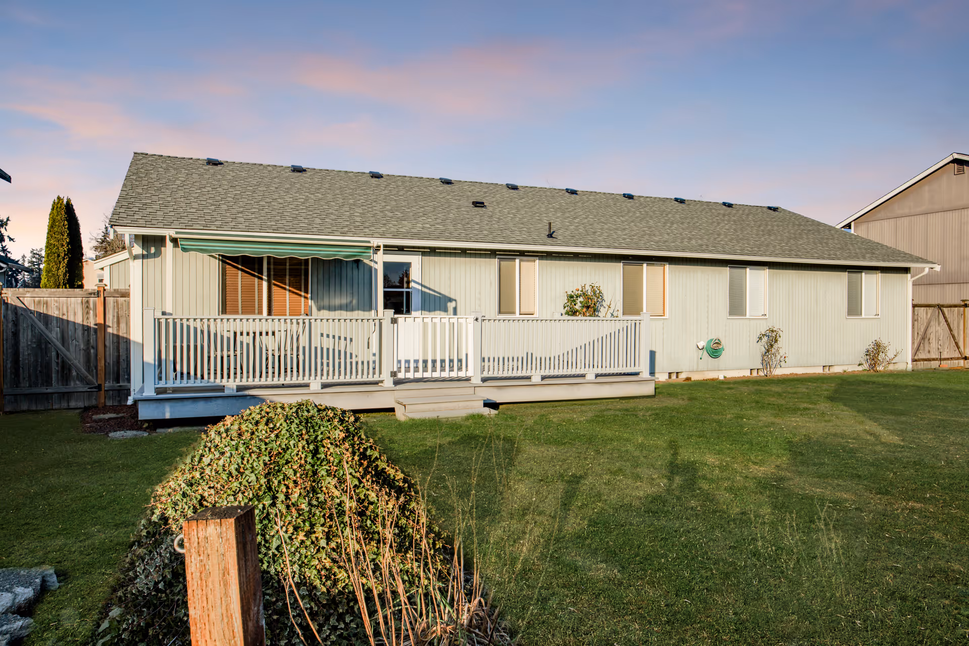 Exterior of Clover Care Adult Family Home: single-story building with deck and green lawn.