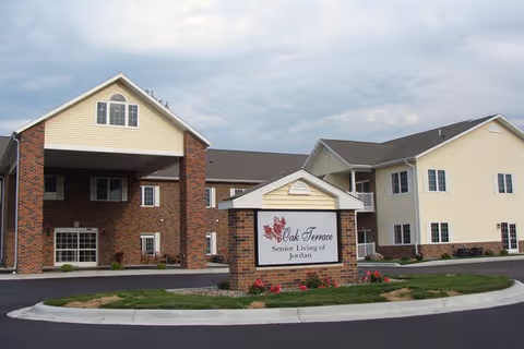 Exterior view of Oak Terrace Senior Living of Jordan with entrance and landscaped sign