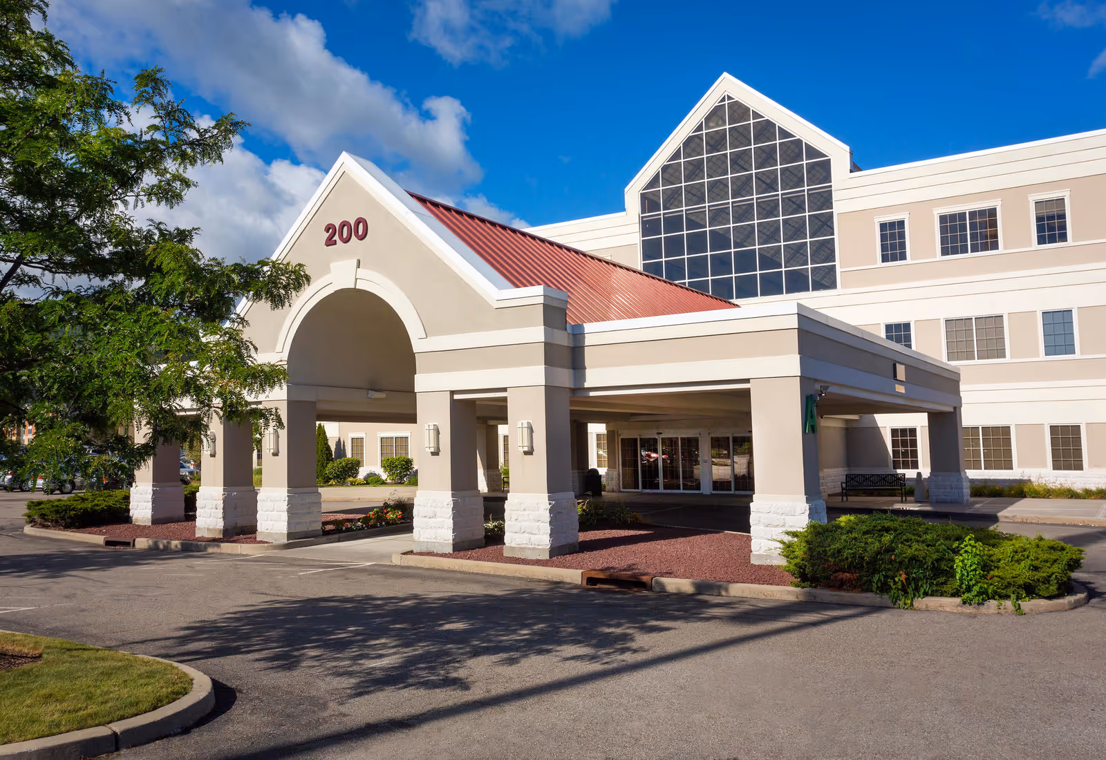 Front entrance of a modern medical facility featuring a porte-cochère and 200.