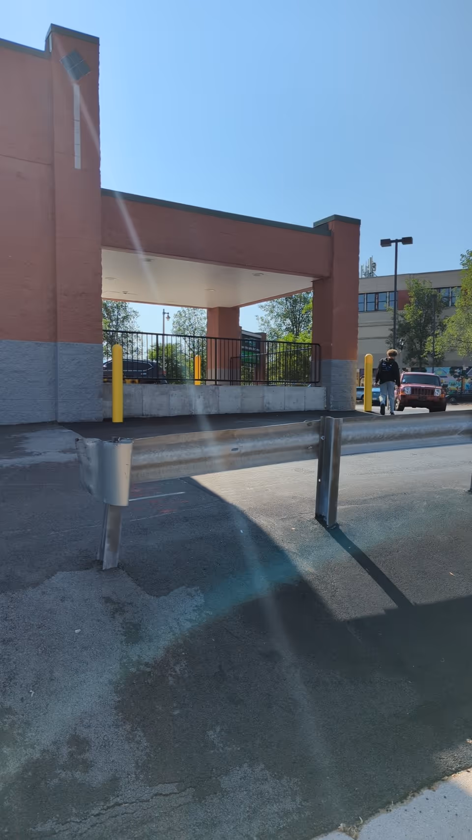 Exterior view of a senior facility entrance with a covered drop-off and parking area.