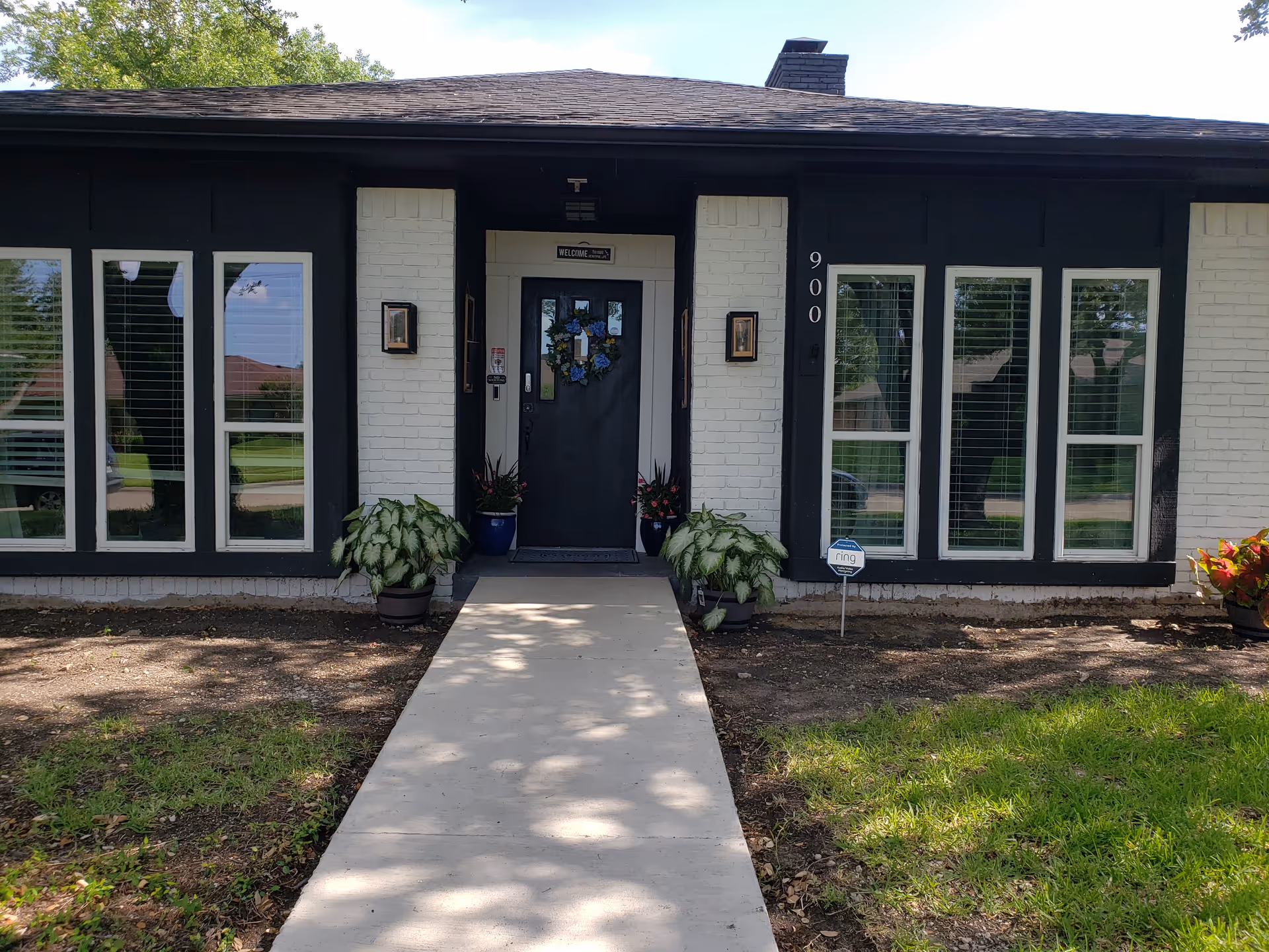 Front entrance of Integrity Residential Care, LLC, a single-story building with black trim and plants.
