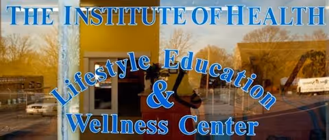 Reflection of a building entrance with The Institute of Health sign and Wellness Center text.