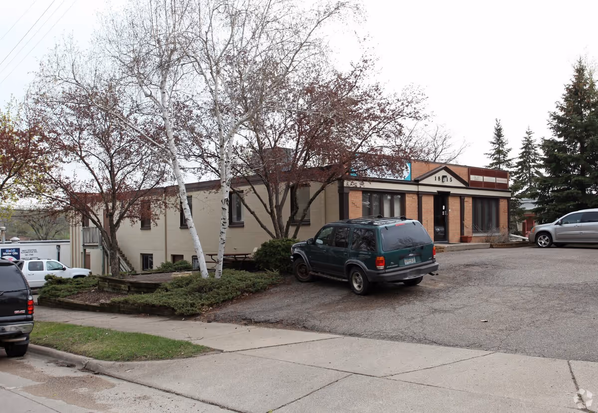 Exterior view of Allegiance Health Care facility with parked cars and trees.