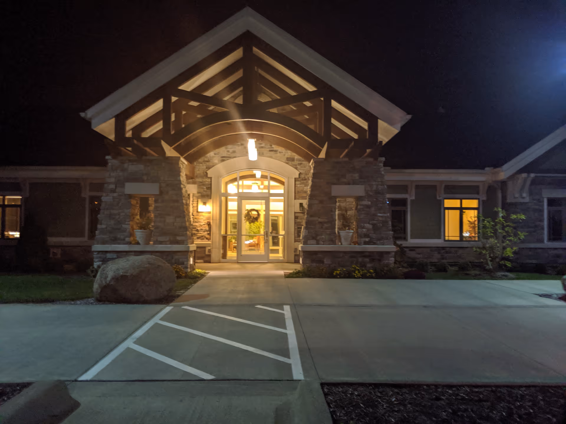 Nighttime view of Lifecare Hospice front entrance with warm interior lighting