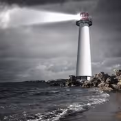 A tall lighthouse on a rocky coastline with a beam shining through stormy clouds.