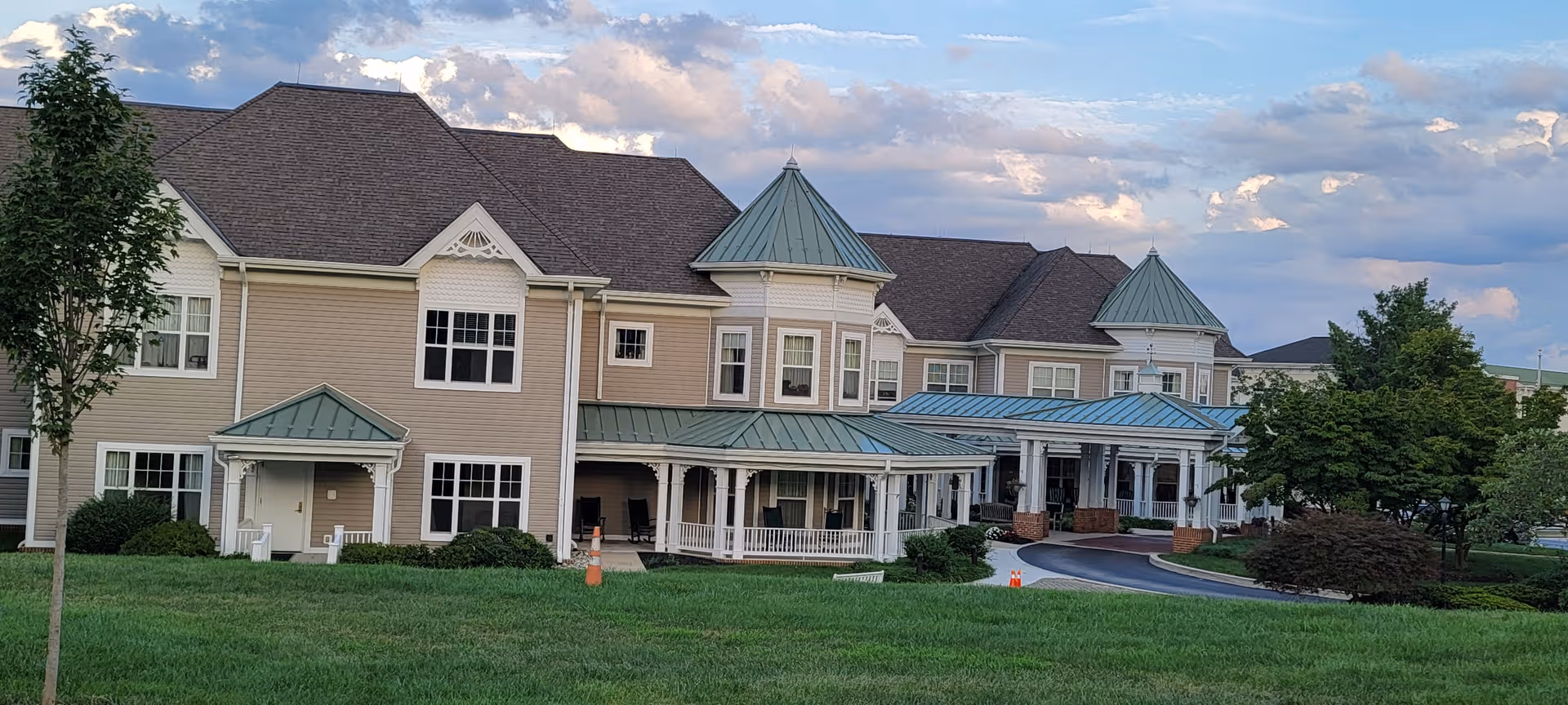 Exterior view of Sunrise of Westtown building with green lawn and covered entrances.