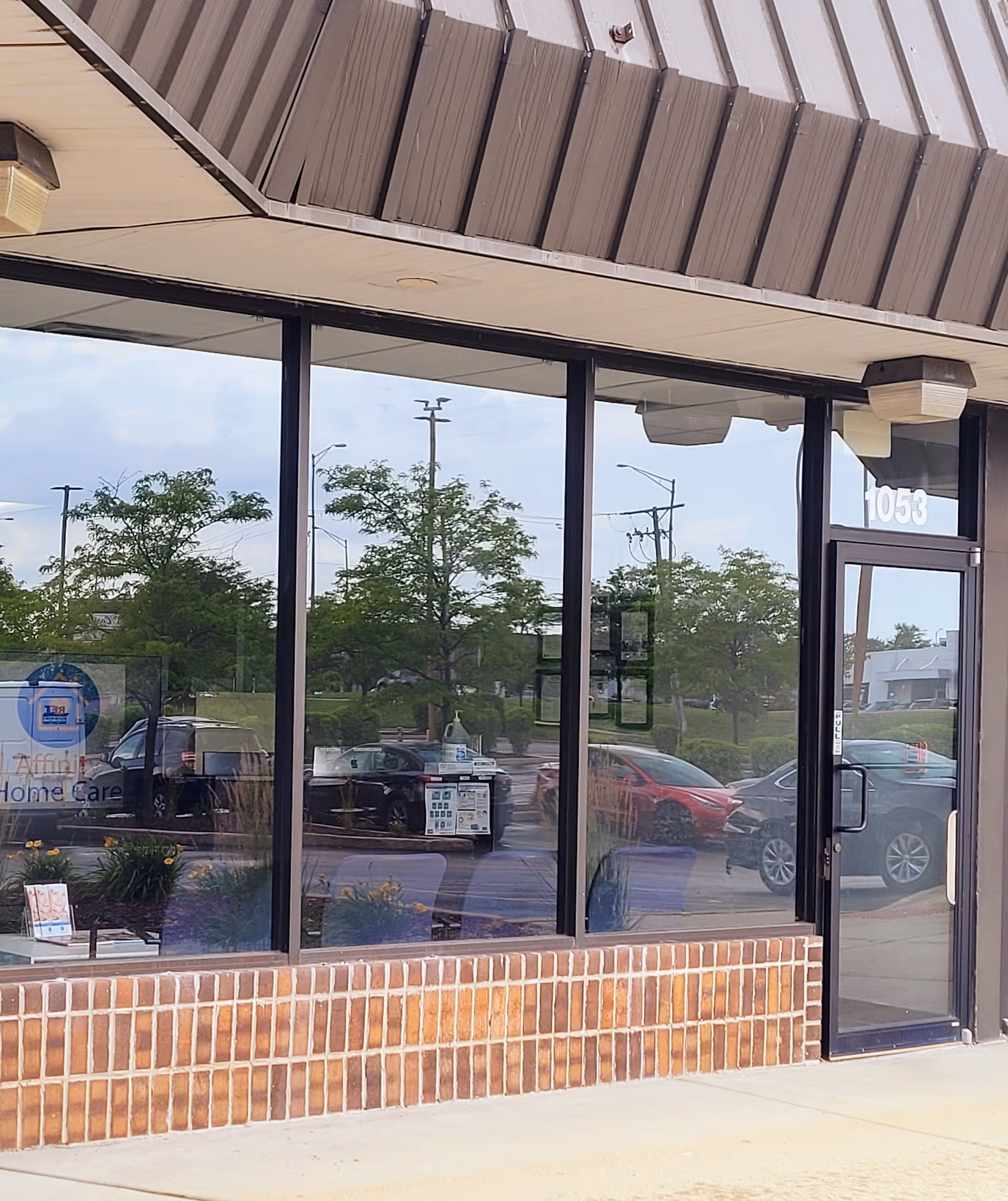 Exterior view of Affinity Home Care Group storefront with large glass windows and brick base.