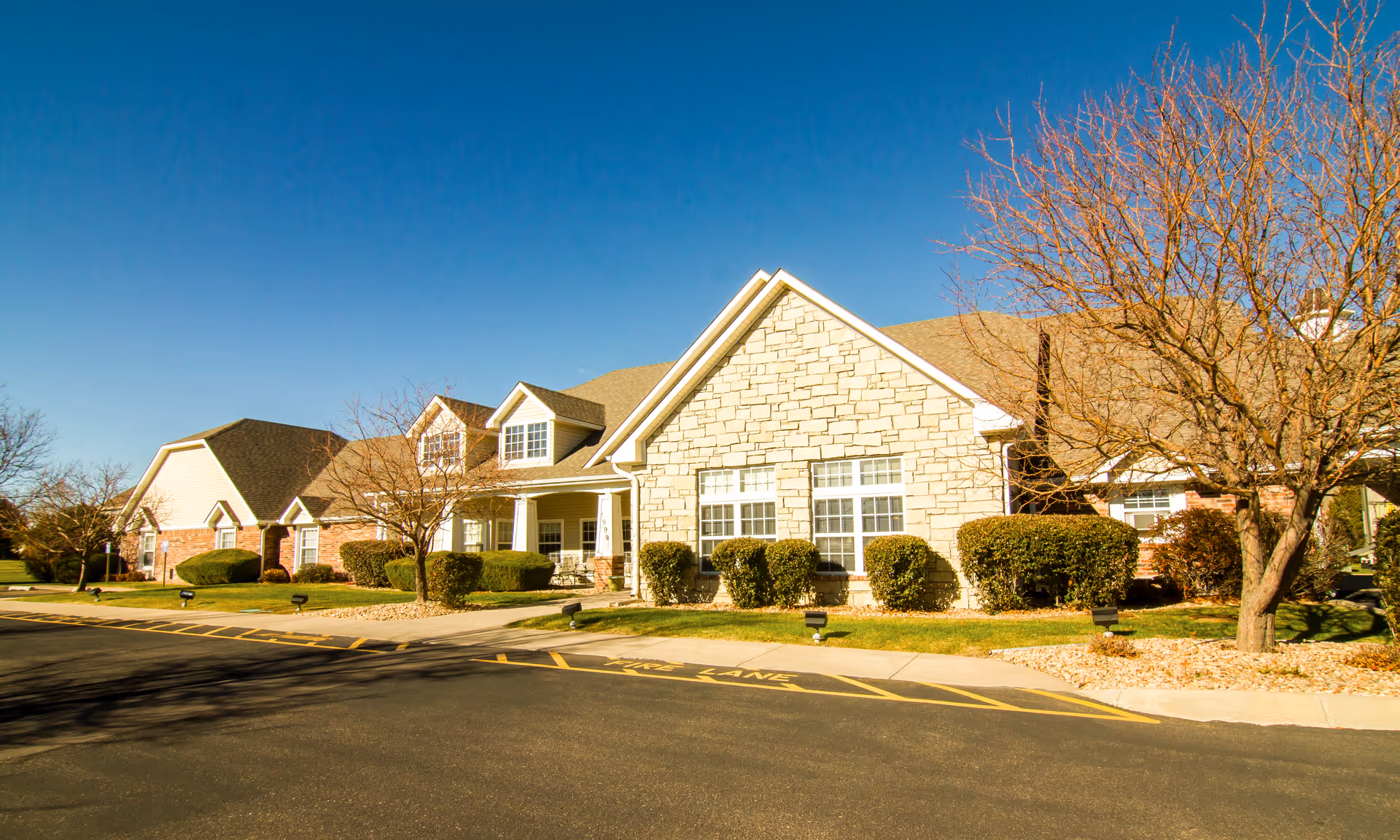 Exterior view of Brookdale Greeley senior living building featuring brick and stone facade.