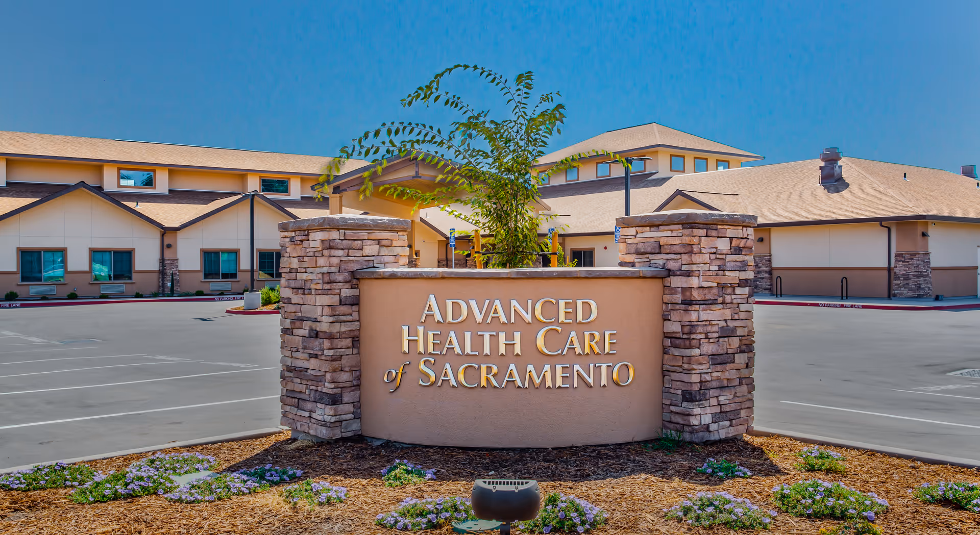 Exterior view of Advanced Health Care of Sacramento with stone sign and parking lot