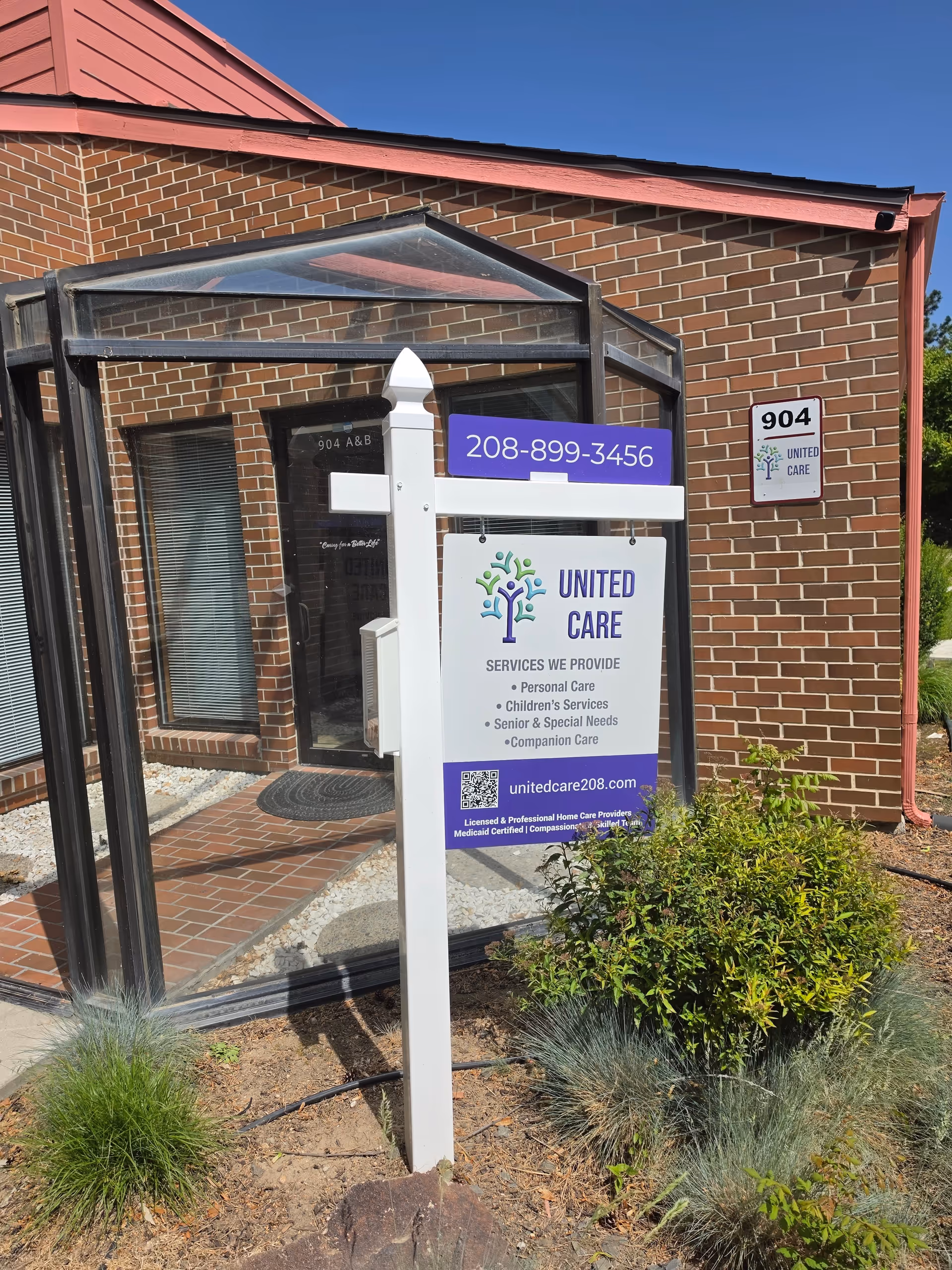 Brick building exterior with glass entry canopy and United Care sign in front.