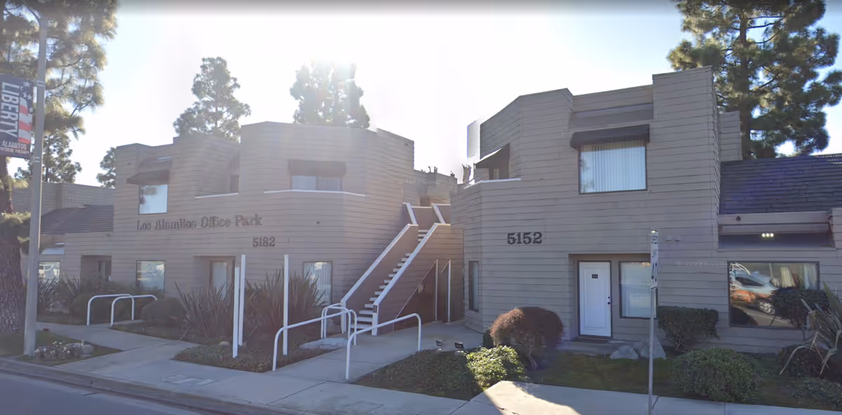 Exterior view of a two-unit office building with stairs and entrances