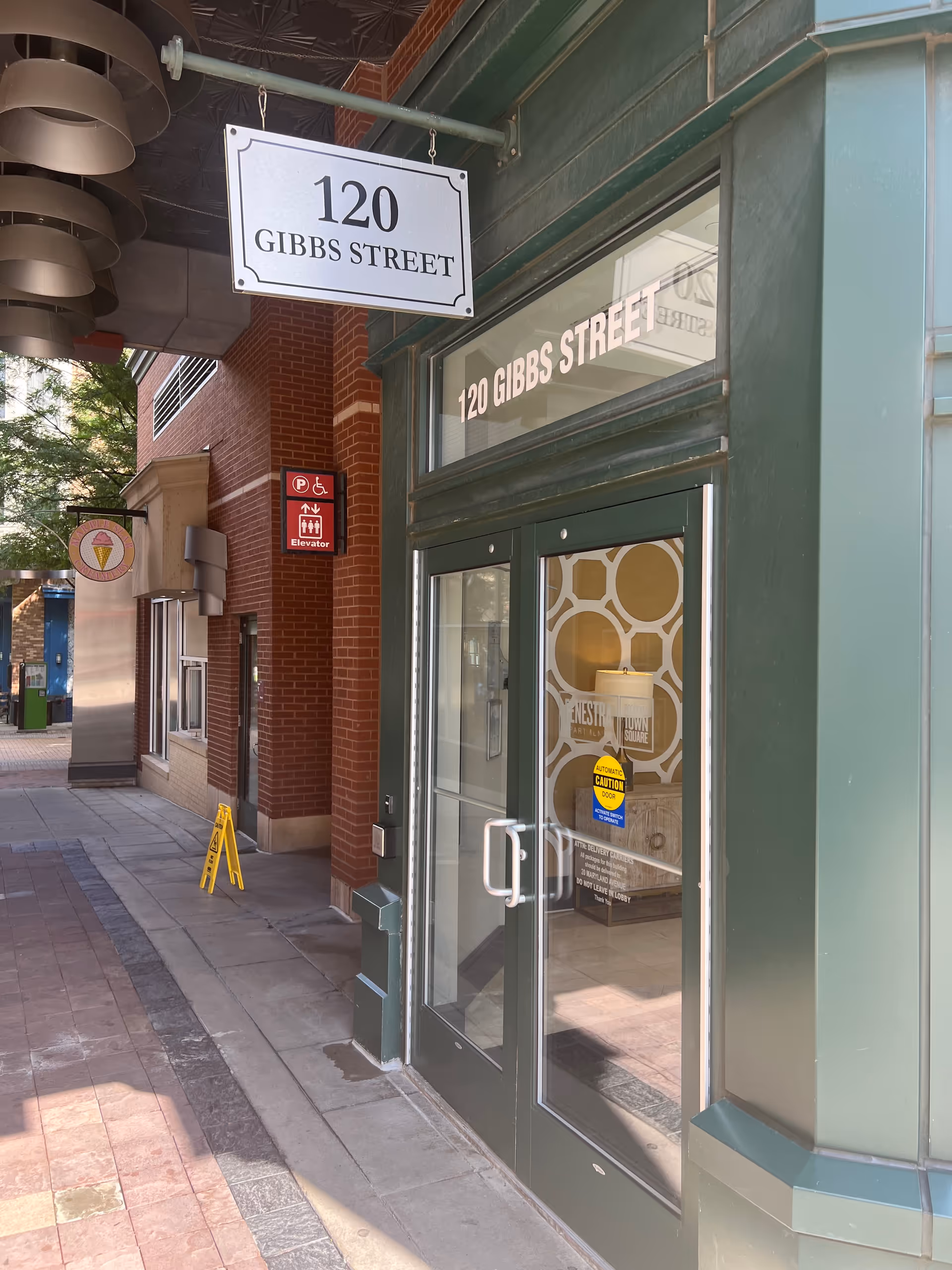 Green storefront with glass doors and a street address sign reading 120 Gibbs Street.