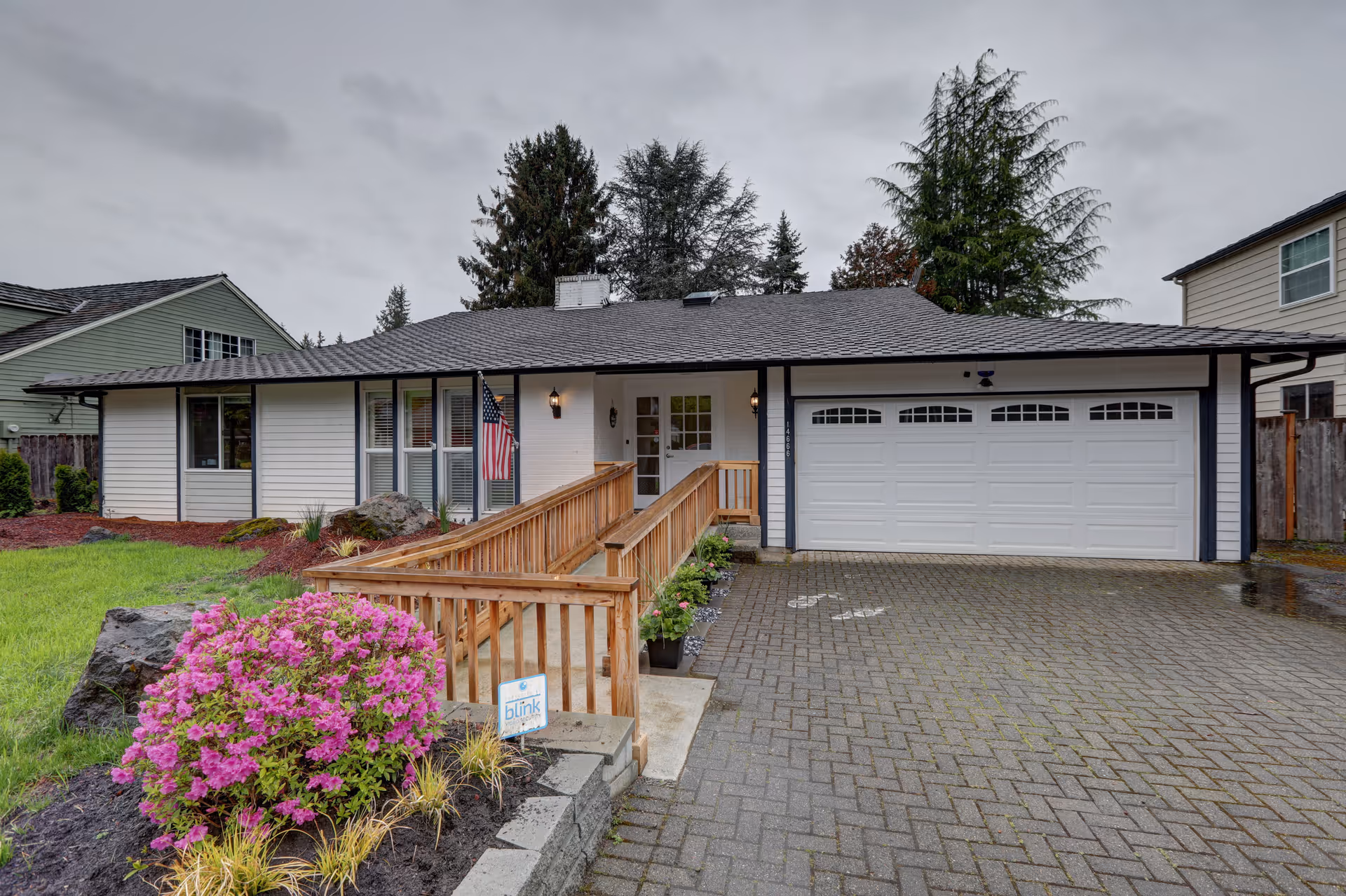 Front exterior of a single-story senior living home with ramp and garage.