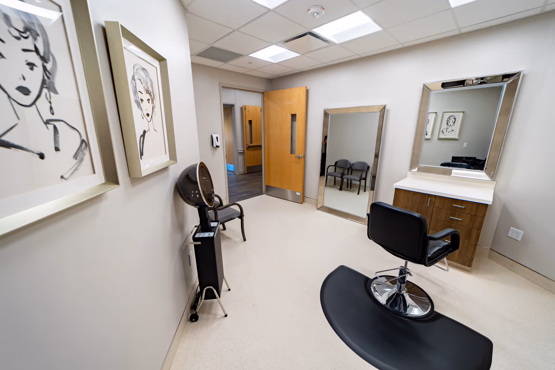 A modern hair salon inside Tangi Pines Nursing Center with a chair, large mirror, and cabinets.