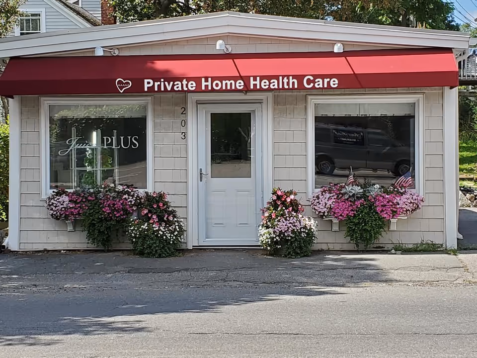 Small storefront with a red canopy and flower planters outside Private Home Health Care
