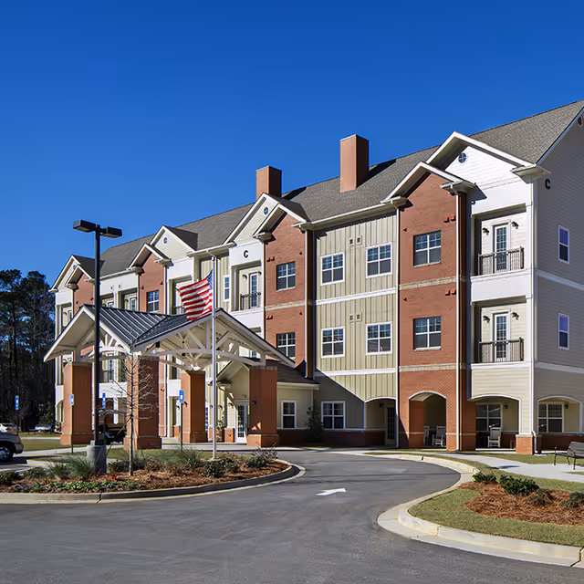 Exterior view of Heartis Fayetteville senior living building with entrance canopy and driveway.