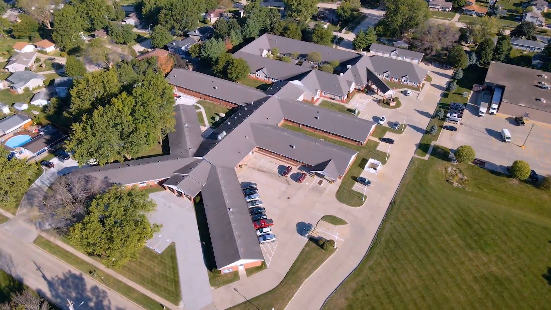 Aerial view of Regency Care Center campus with connected buildings, parking, and green fields.