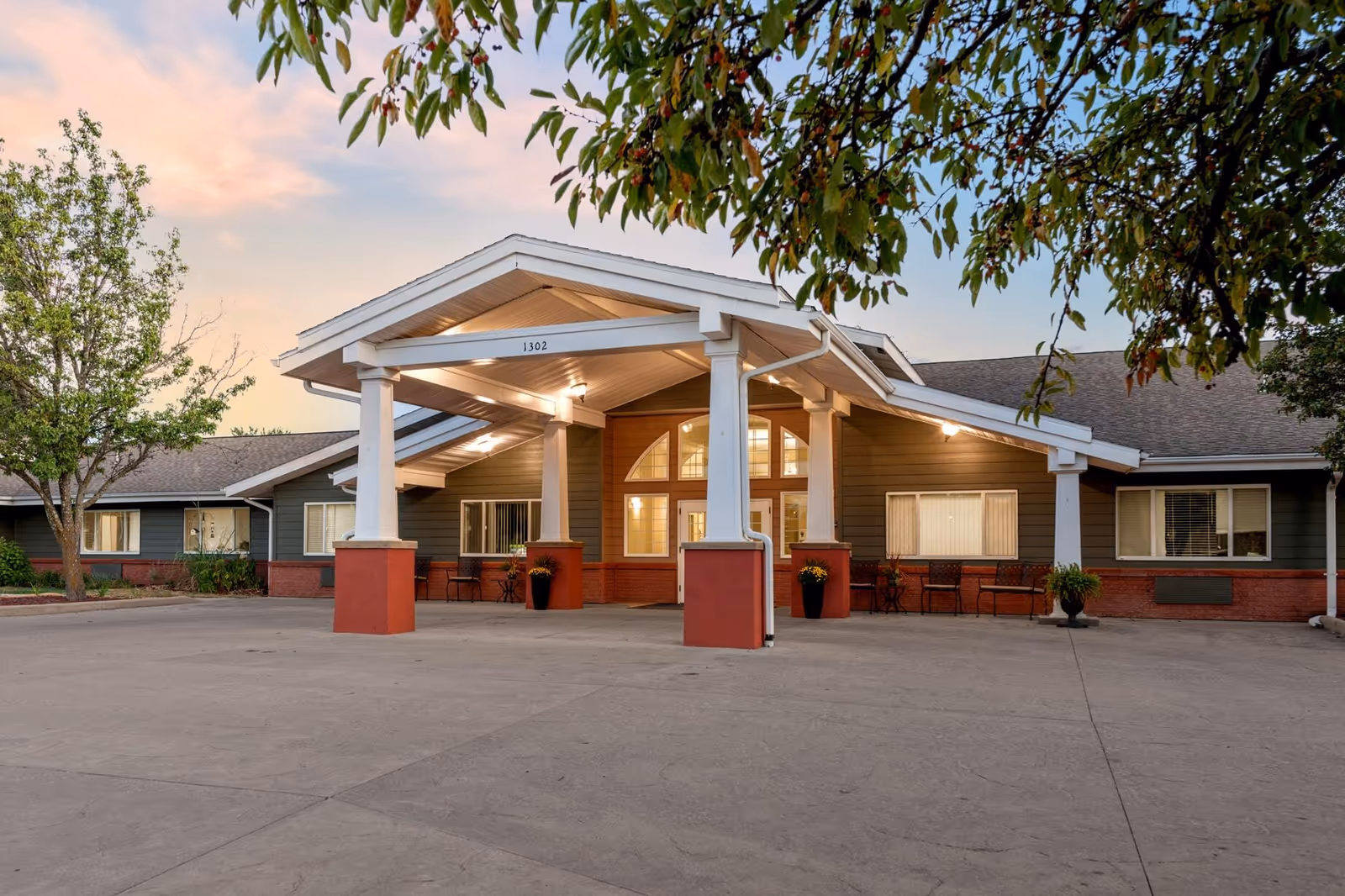 Senior living facility entrance with a covered front portico and seating.