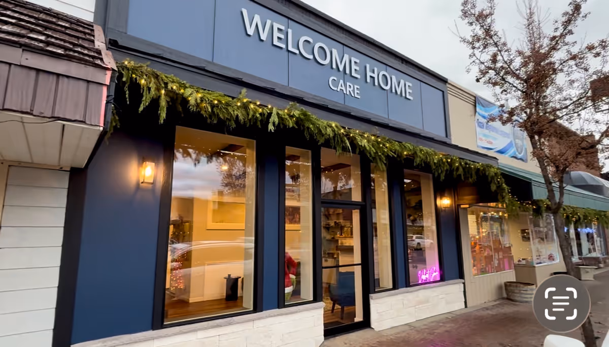 Blue storefront reads 'Welcome Home Care' with garlands along the front windows