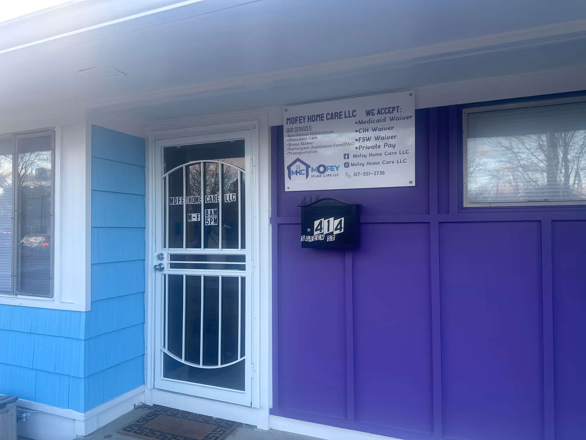 Front entrance of a colorful building labeled Mofey Home Care LLC with a metal security door.