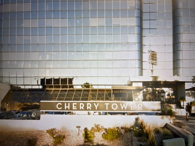 Front exterior of a tall glass building with a Cherry Tower sign.
