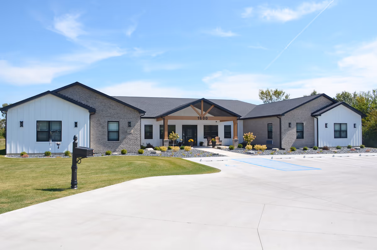 Single-story senior living facility with a modern entrance and spacious parking in front.
