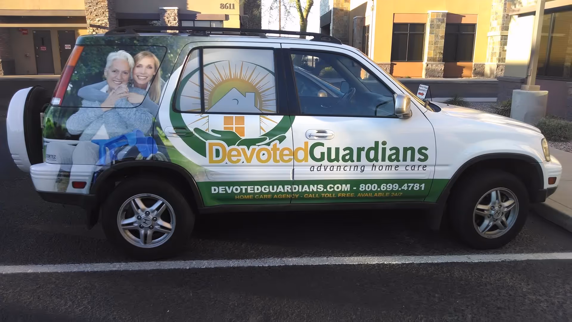 Exterior of a Devoted Guardians home care branded van parked in a lot.
