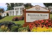 Front view of Ridgewood Manor Health and Rehabilitation with landscaped lawn and sign.