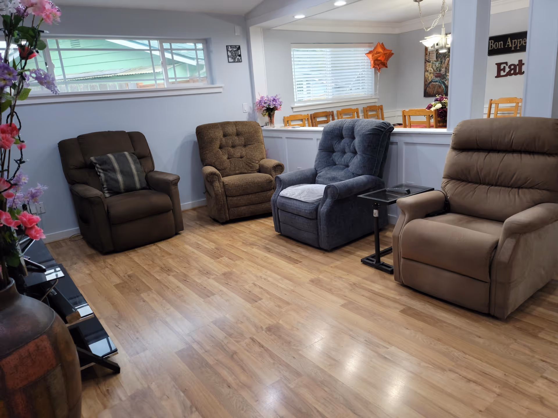 Cozy lounge area with multiple recliner chairs and a dining space in the back.