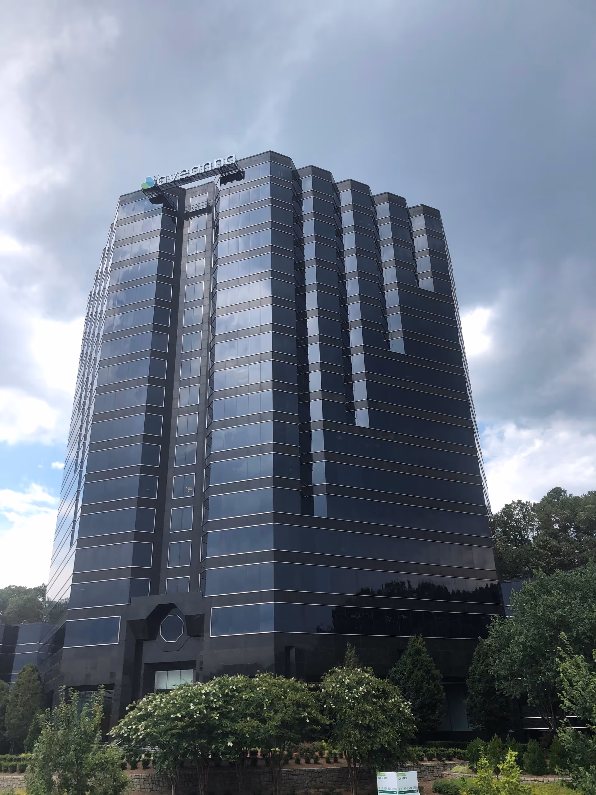 Tall dark glass building with Aveanna Healthcare sign on the roof.