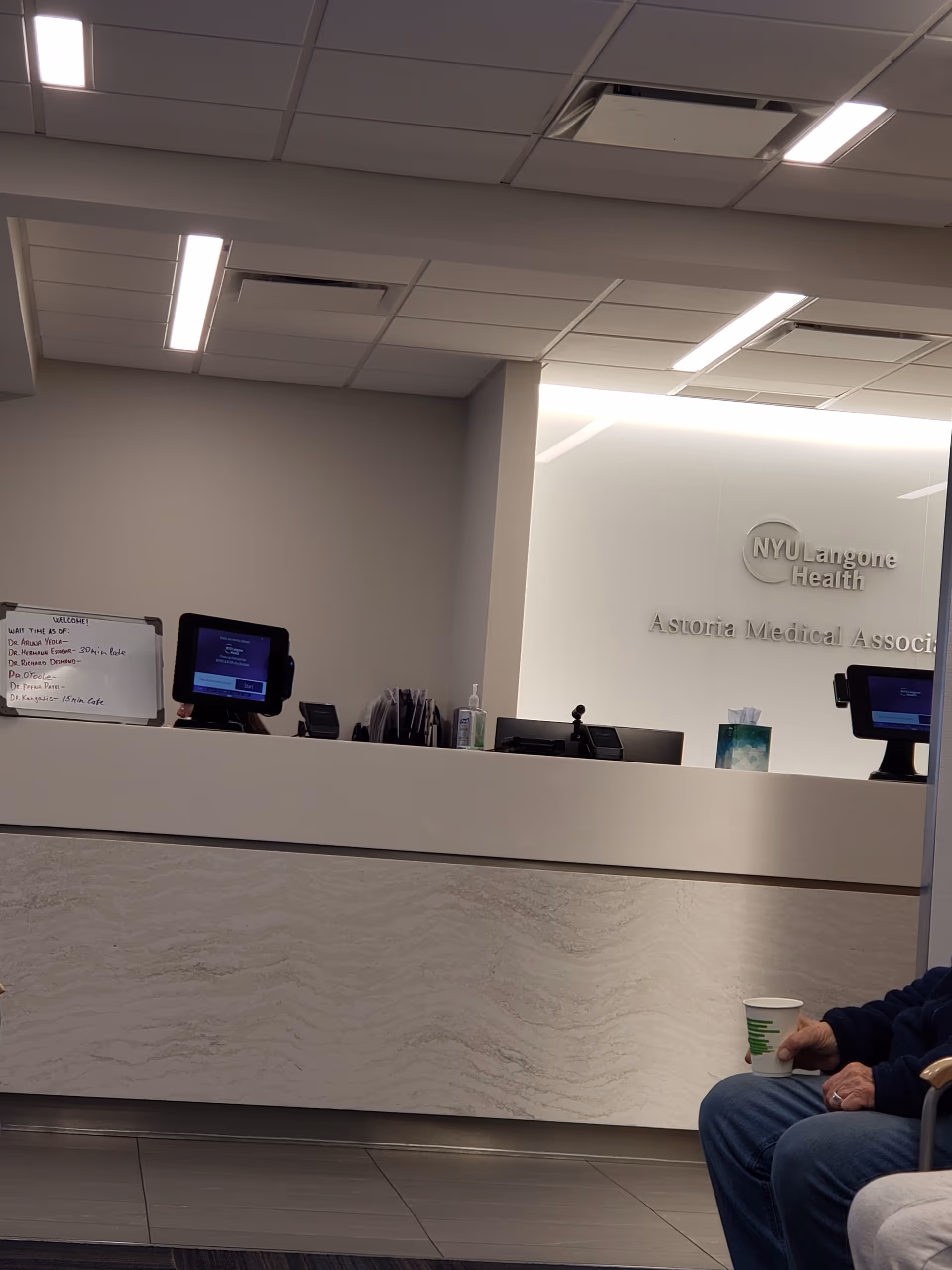 Interior reception area of NYU Langone Astoria Medical Associates with front desk and signage