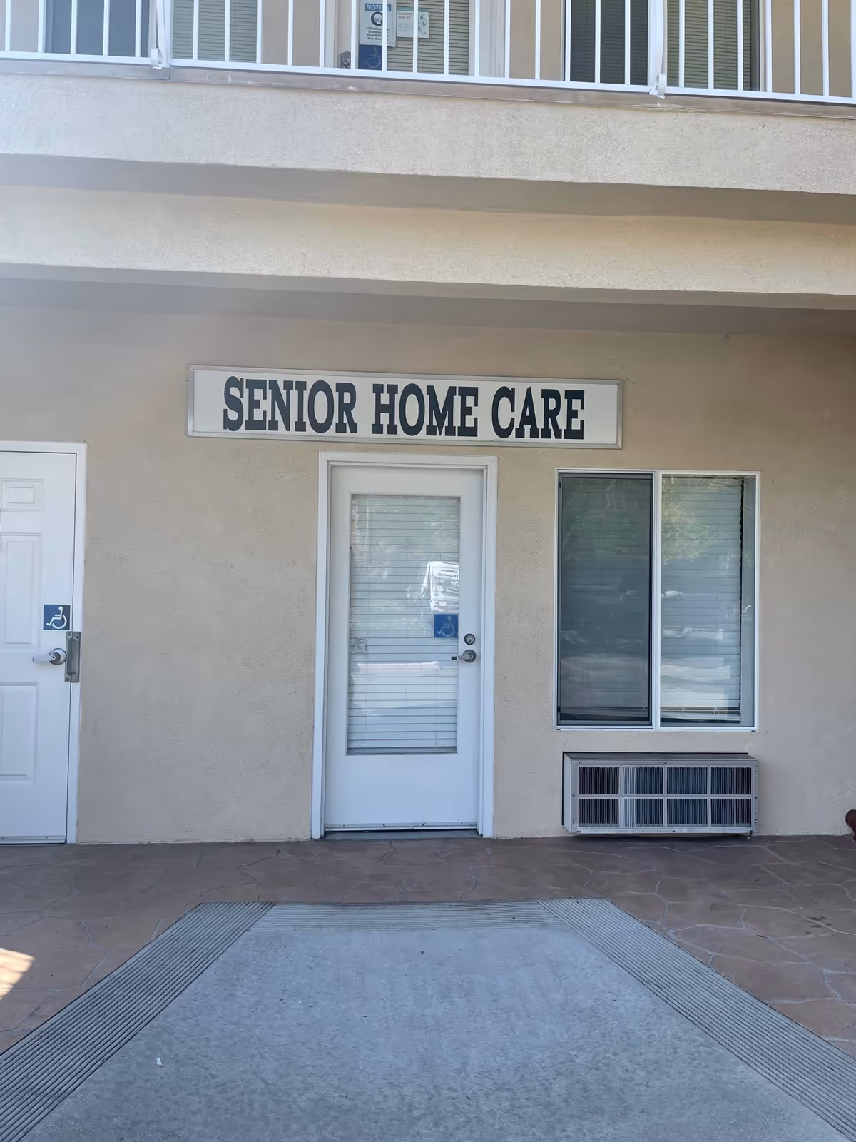 Exterior of a senior home care facility showing the front entrance and sign.