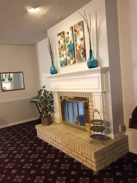 Interior living room with a white mantle fireplace, artwork, and turquoise vases.