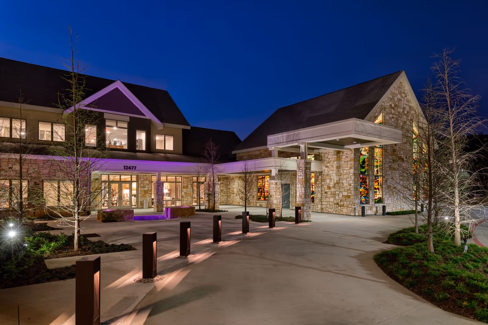 Night view of the Faith Presbyterian Hospice building exterior with lit entrance and stone facade.