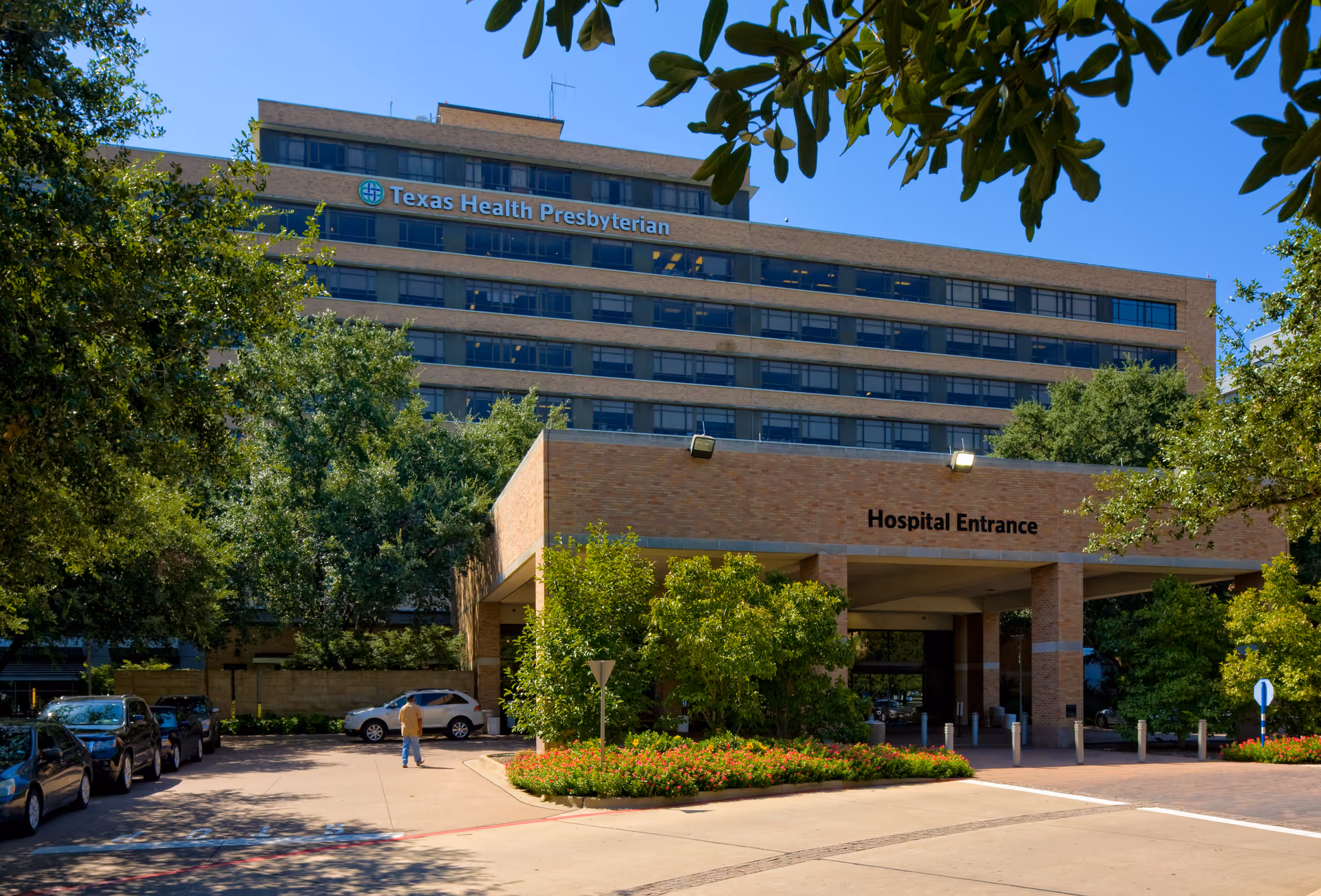 Exterior view of Texas Health Presbyterian hospital with brick entrance and surrounding greenery.