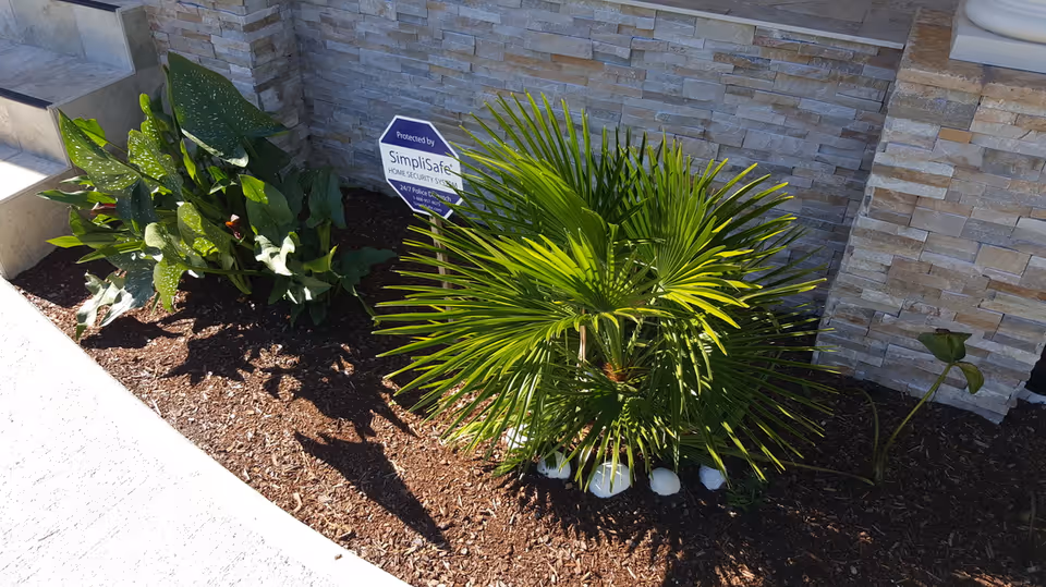 Sunset Home Care exterior featuring a stone wall, steps, and landscaped plants.