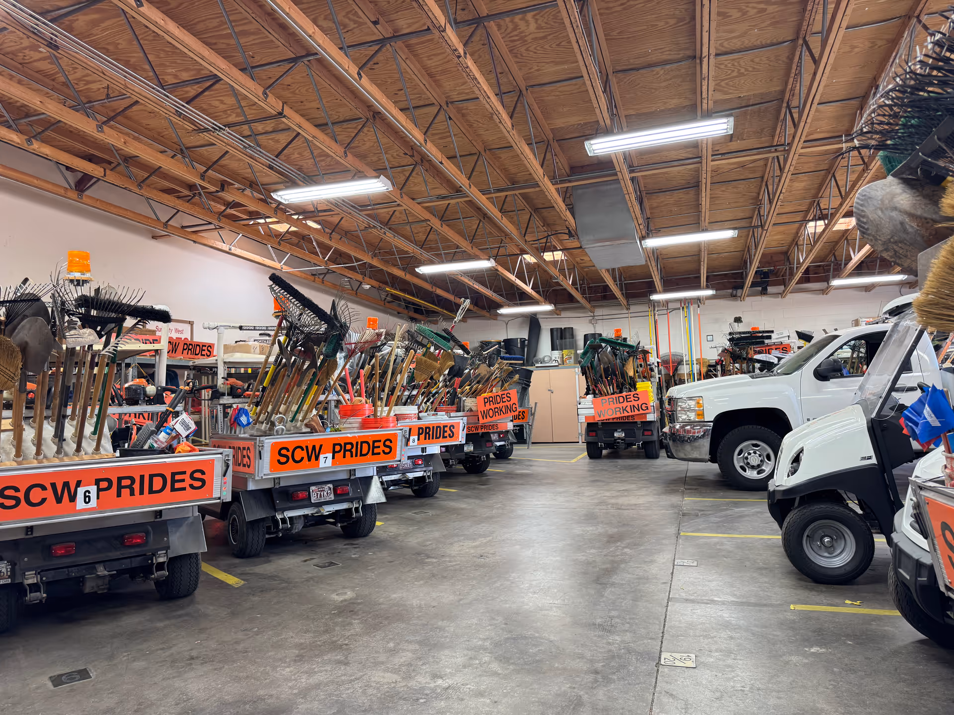 Indoor maintenance shop at Sun City West with carts of cleaning tools and vehicles.