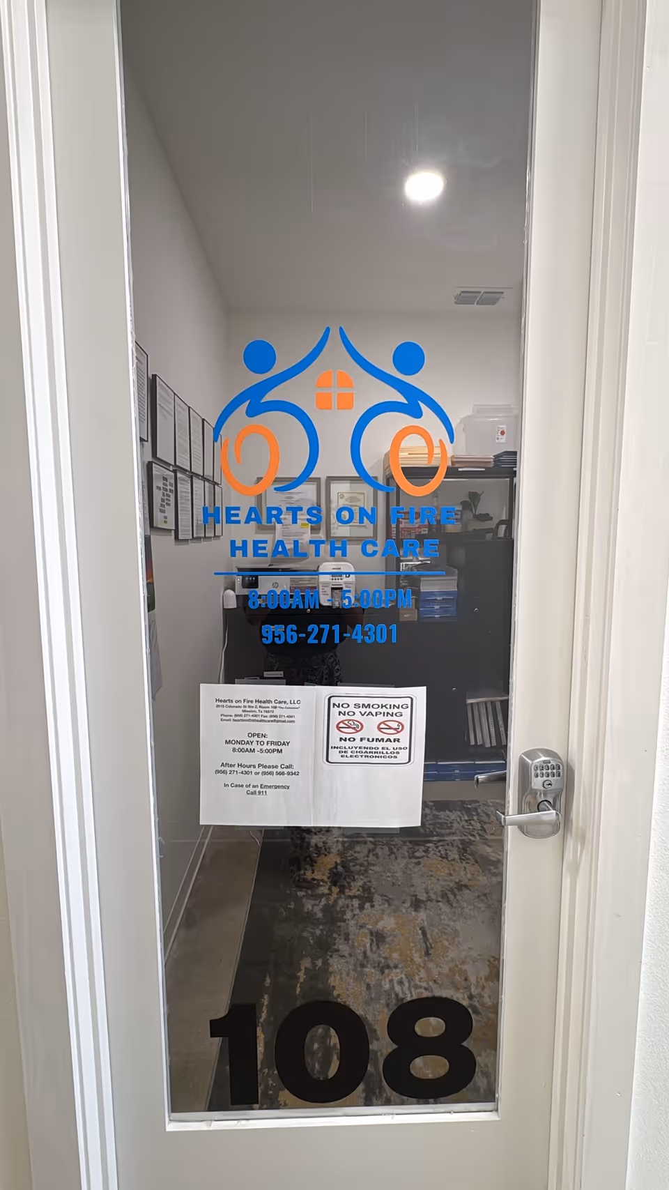 Glass door with Hearts On Fire Health Care logo, room 108, interior hallway view.