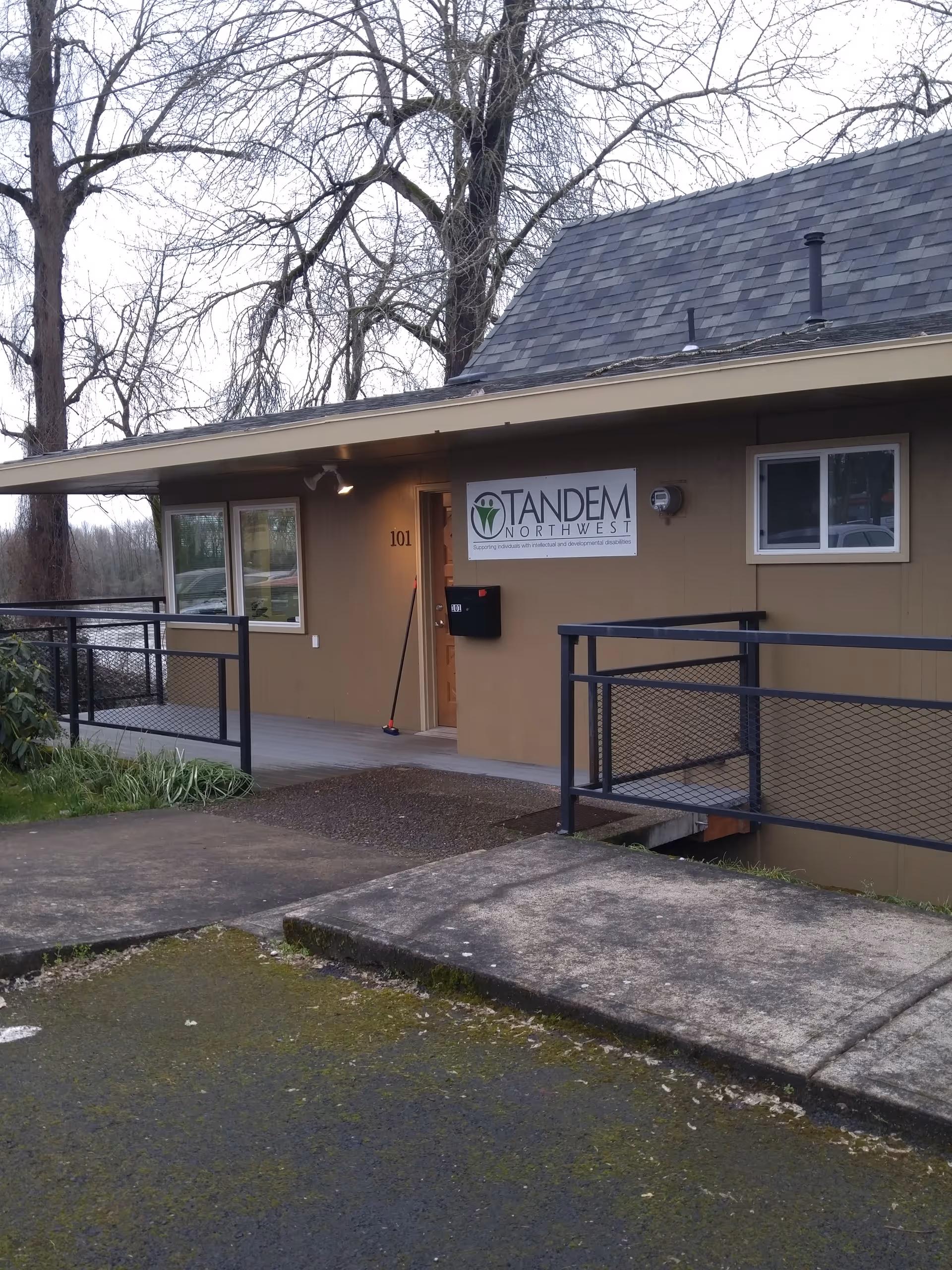 Exterior view of a Tandem Northwest facility entrance with ramp and sign.