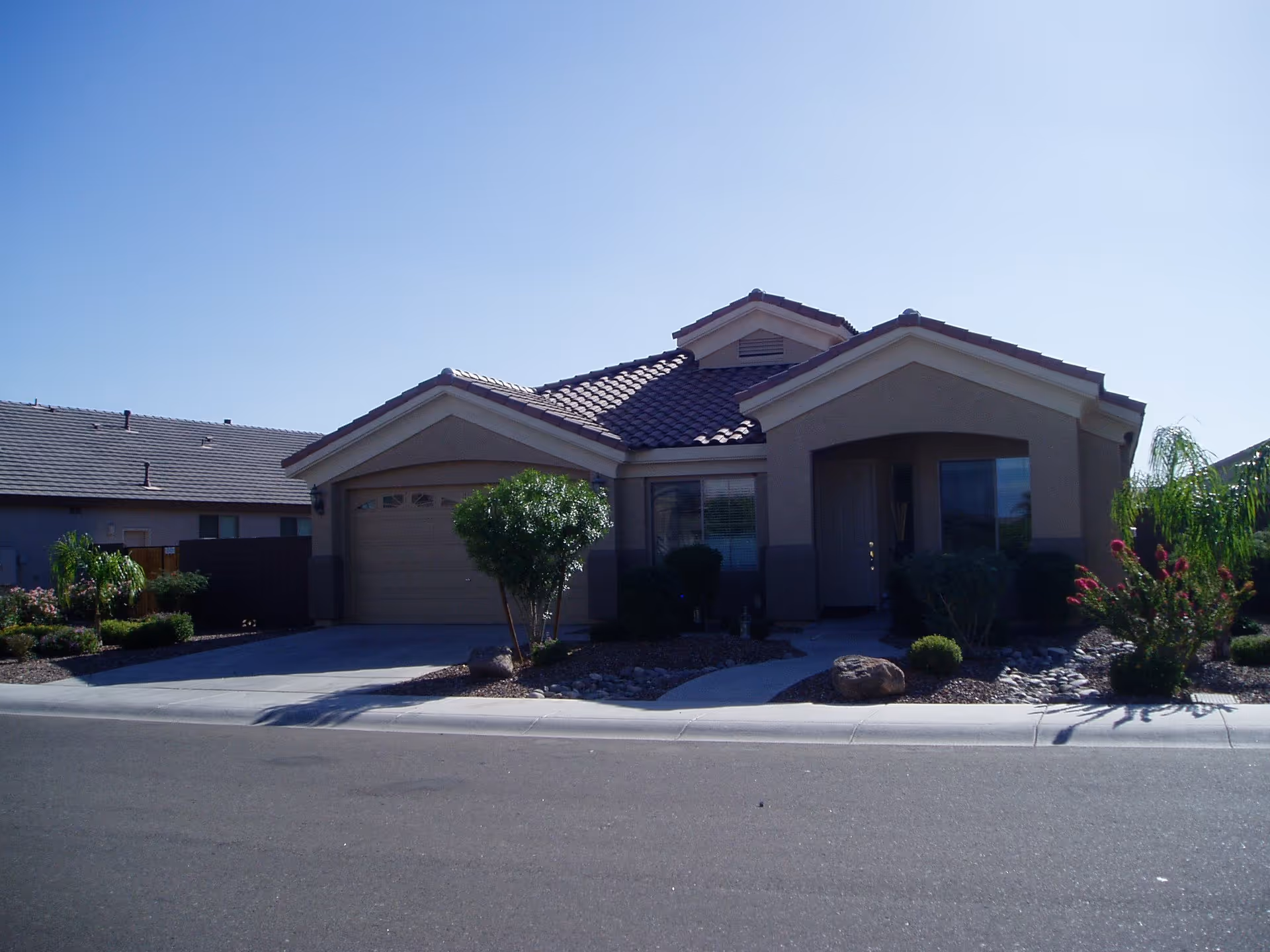 Single-story house-style building with a two-car garage and desert landscaping.
