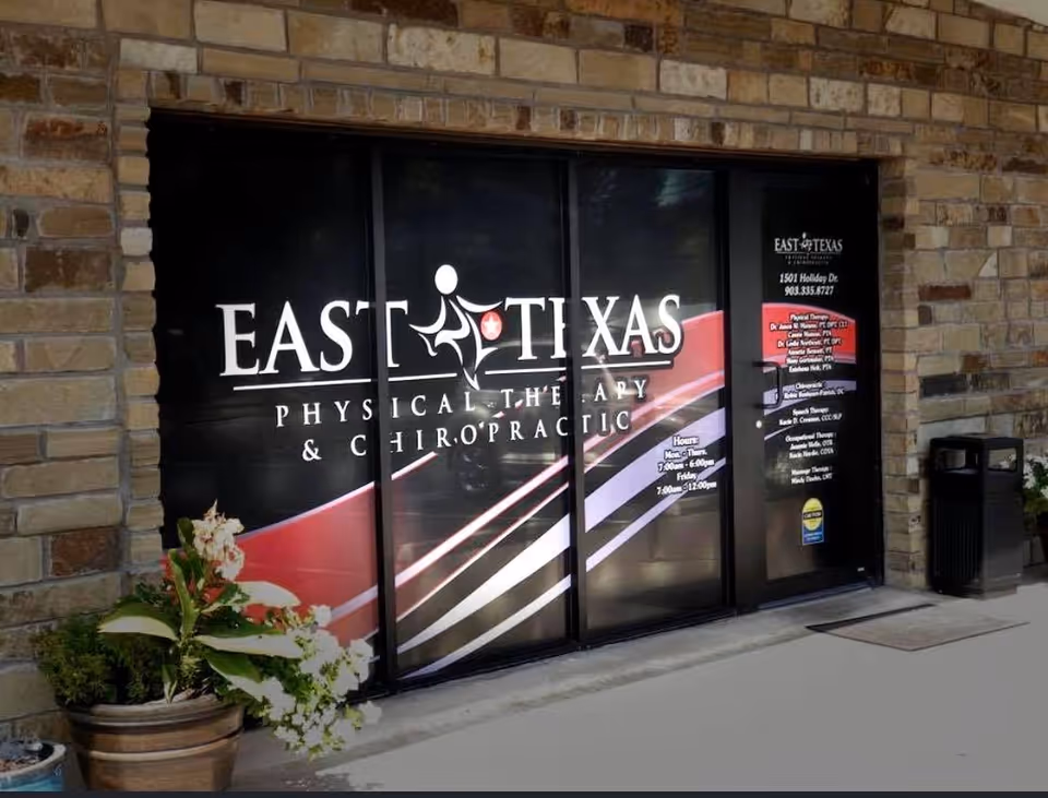Exterior view of a stone-building entrance with East Texas Physical Therapy glass doors.
