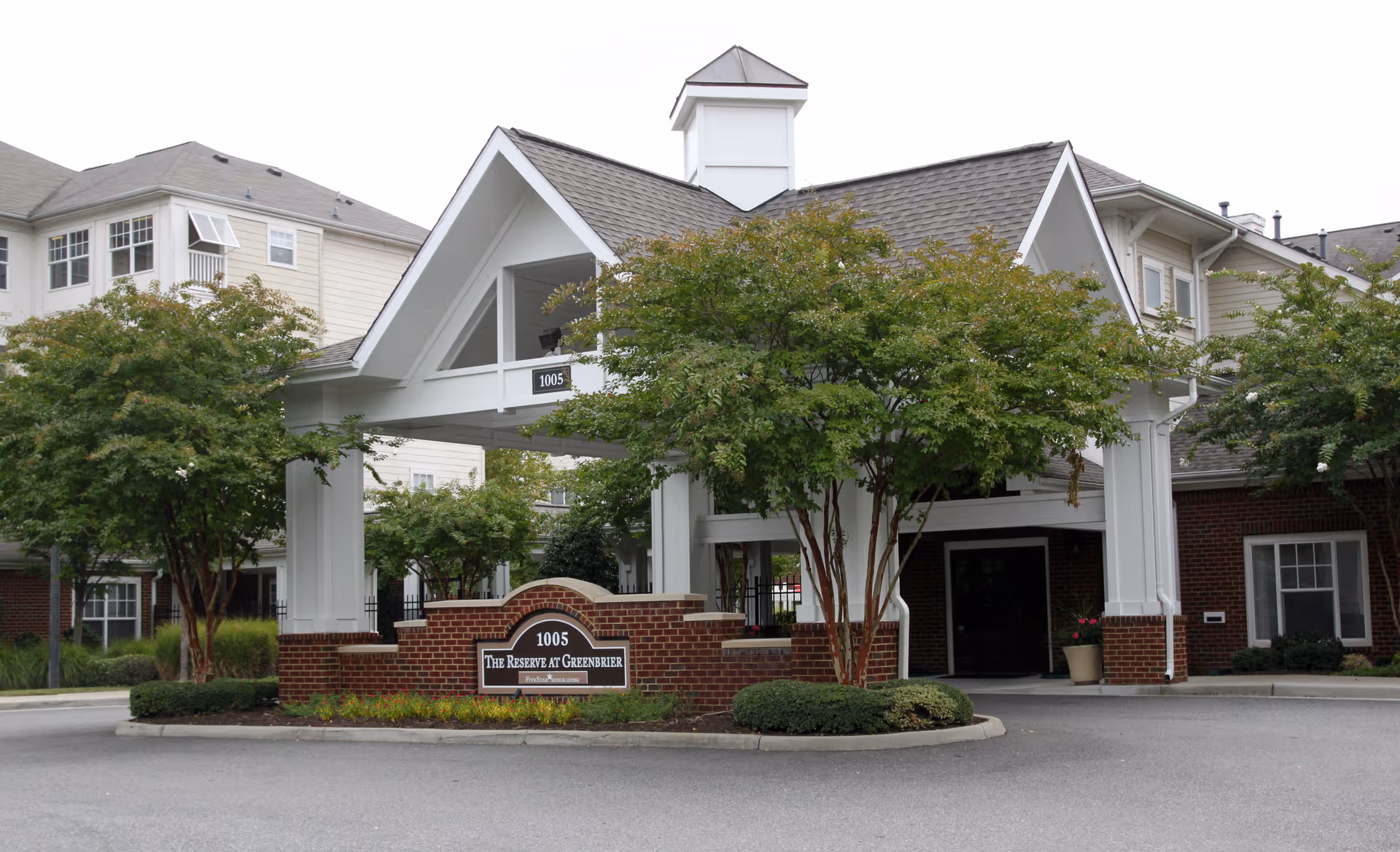 Exterior view of The Reserve at Greenbrier entrance with trees and brick signage.