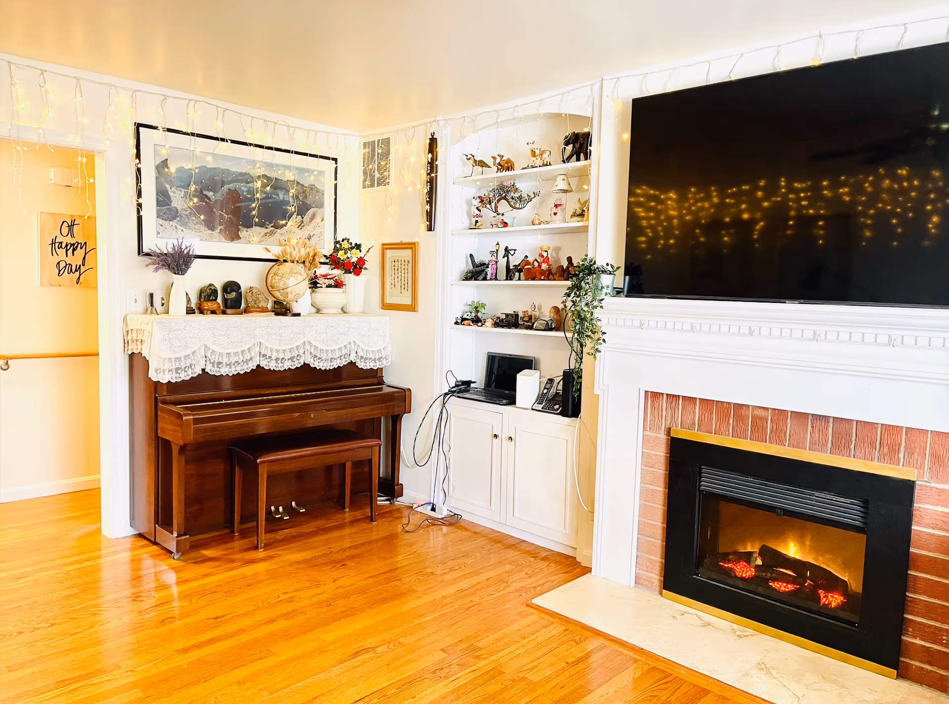 Cozy living room with piano, fireplace, and decorative shelves