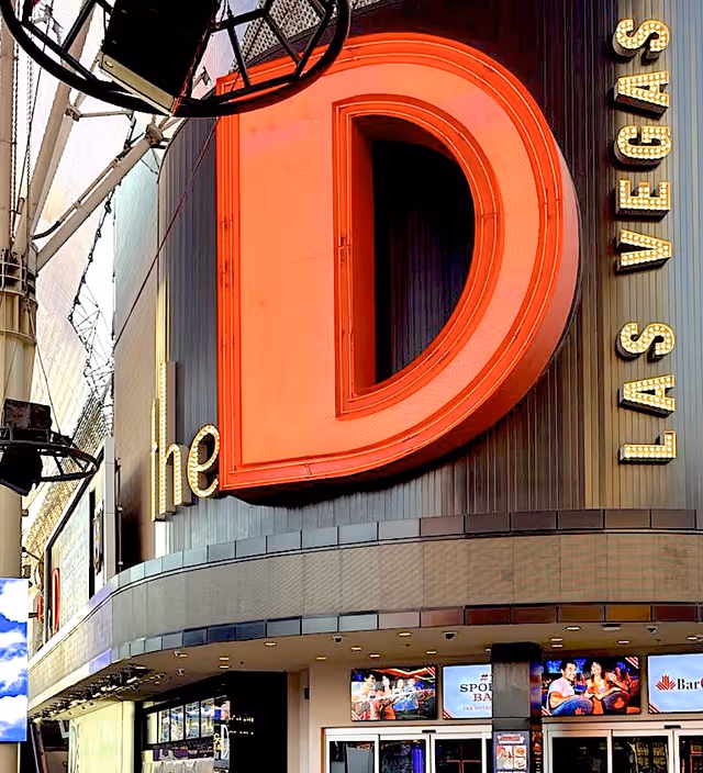 Close-up of a large red D sign on a Las Vegas building storefront.