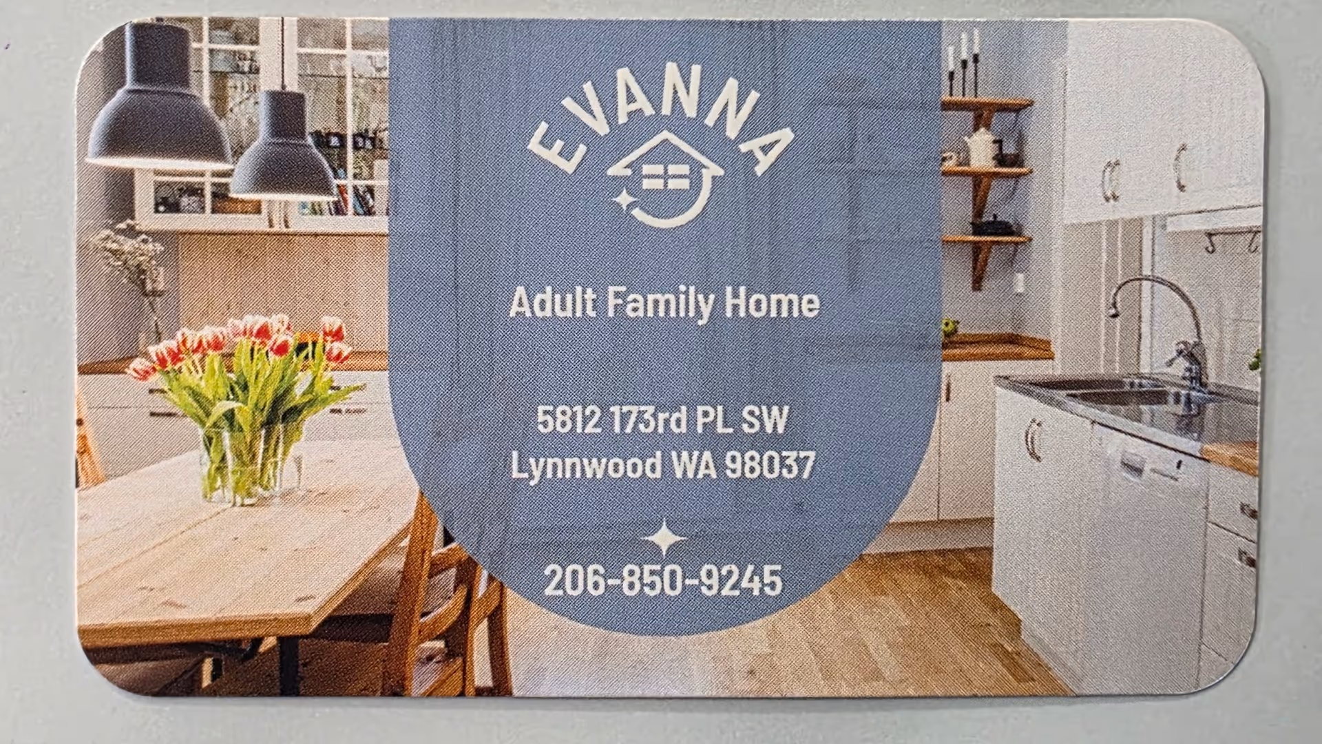 Blue Evanna sign card centered in a modern kitchen and dining area.