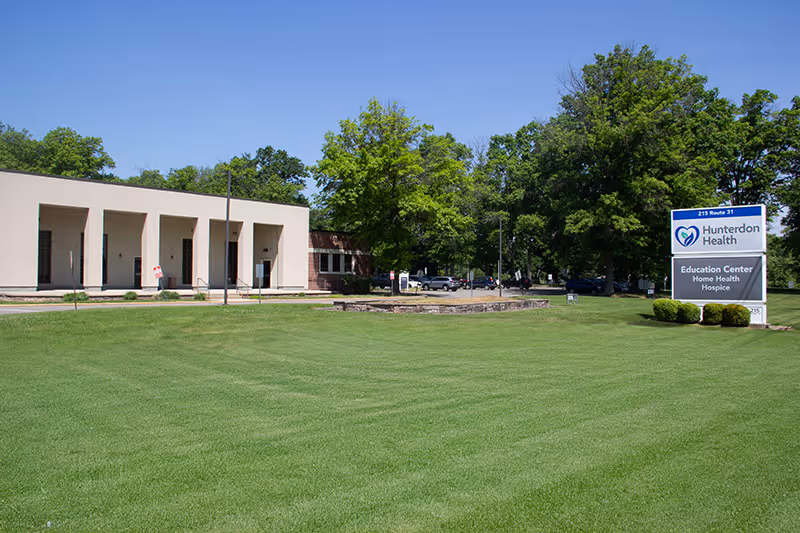 Exterior view of Hunterdon Health facility with a green lawn and signage.