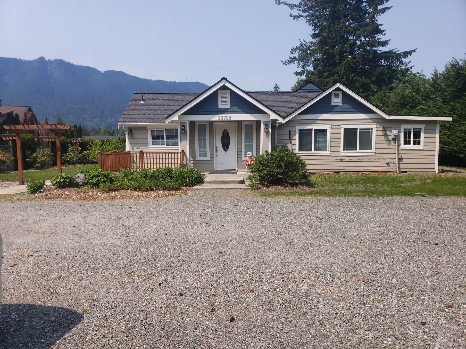 This photo shows a front view of a single-story senior care building with a gravel driveway.