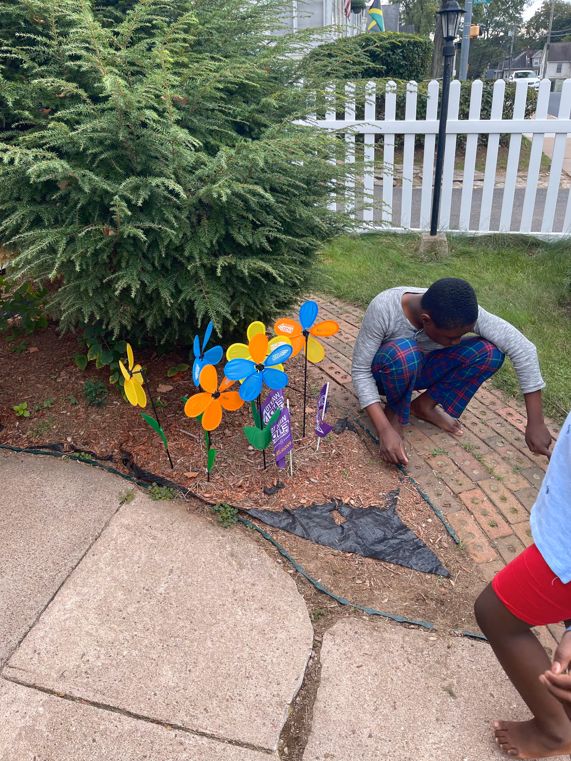 Outdoor garden area at Noble Happy Family Home with a person near colorful pinwheels.