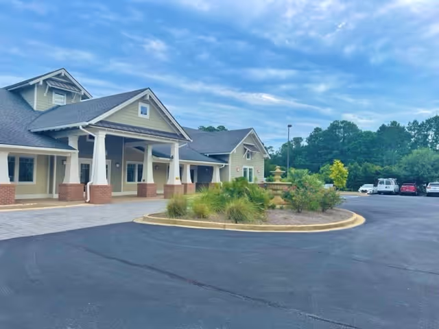 Exterior view of The Landings of Georgetown with a circular landscaped island and fountain.
